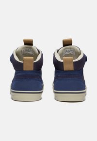 Baskets montantes bleu marine en matériau en daim, avec une tige en tissu texturé, des accents crème, une semelle blanche et des languettes à l'arrière pour un enfilage facile.