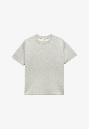 T-shirt gris à manches courtes avec un col rond, fabriqué en tissu doux, présentant une subtile texture chinée et une petite étiquette à l'intérieur du col.