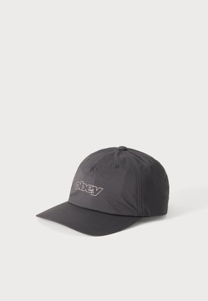 Czarna czapka z daszkiem z białym konturem logo "obey" z przodu, prezentowana na jednolitym jasnym tle.