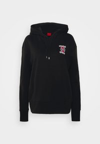 Černá mikina s kapucí a šňůrkami, na níž je menší červená květinová grafika a text "HUGO" na horní levé části hrudi.