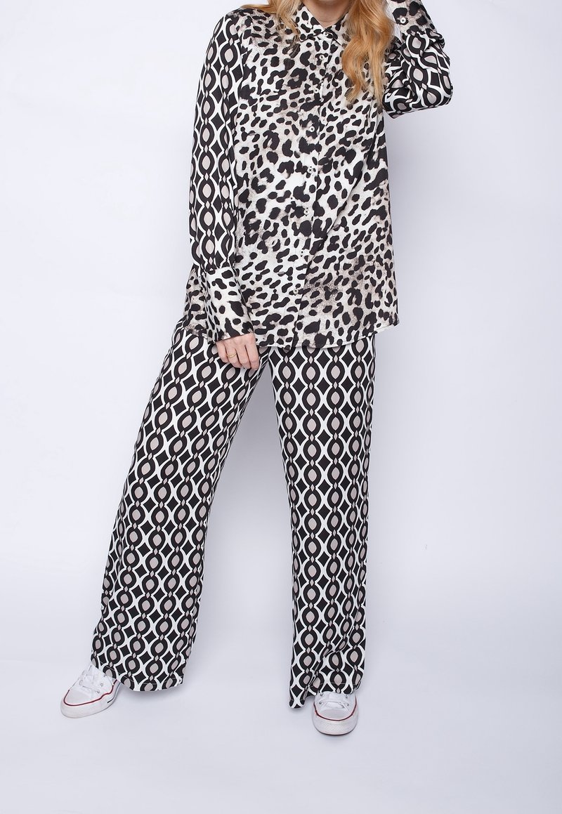 Black and white leopard print shirt with button closure paired with wide-leg patterned pants. Fabric appears smooth with a lightweight texture.