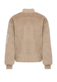 Beige strukturierte Bomberjacke mit hohem Kragen, gerippten Bündchen und einer Akzenttasche am linken Ärmel. Weicher Stoff mit einem gemütlichen Erscheinungsbild.