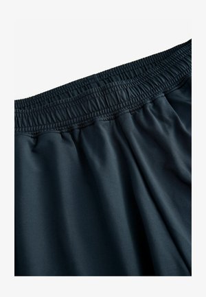 Mørke elastiske shorts med en blød, glat tekstur og en løs pasform, der har subtile sammenkrøllede detaljer ved taljen.