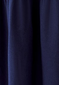 Tamsiai mėlynas medvilnės audinys su lygiu paviršiumi, turintis vertikalių raukšlių. Medžiaga atrodo lengva ir audžiama.