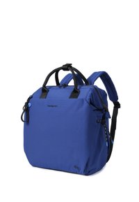 Sac à dos bleu avec poignées noires et bretelles rembourrées, poche avant, détails de fermeture éclair latéraux et logos de marque visibles sur le tissu.