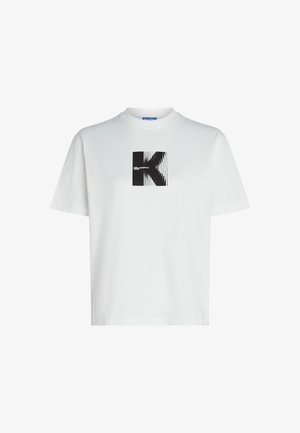 Bijela pamučna majica s kratkim rukavima, sa crnim grafičkim dizajnom slova "K" u kvadratu sa trakama, okrugli izrez, ležeran kroj.