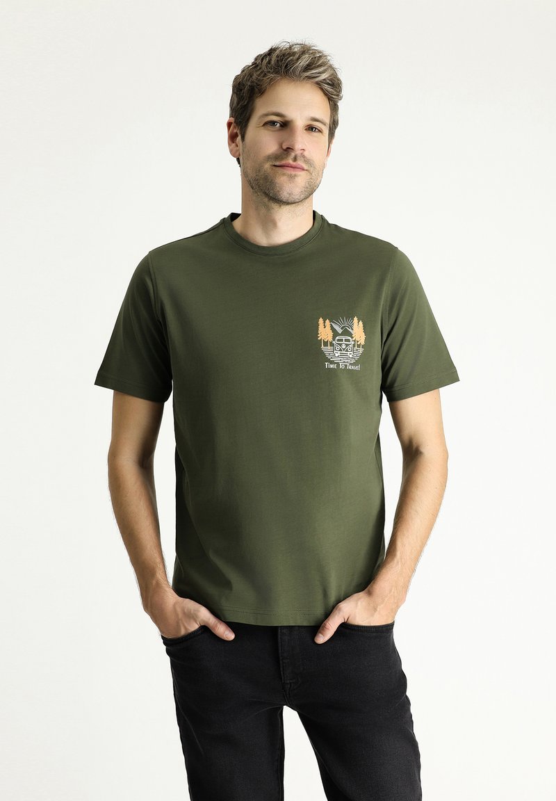 Camiseta de algodón verde oliva con cuello redondo, mangas cortas y un gráfico frontal que presenta una furgoneta, árboles y el texto "ES HORA DE VIAJAR."