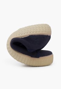 Námorná plátenná papuča s flexibilnou, textúrovanou smotanovou gumovou podrážkou. Má zložený dizajn pre úložný priestor. Hladký zvršok s vystuženým šitím.