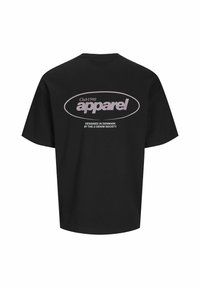 Svart bomull T-skjorte med korte ermer, med et stort ovalt logo i lys rosa på ryggen som sier "Club1990 apparel."