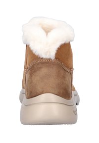 Bruine suède enkelboots met een zachte witte nepbont kraag en een beige rubberen zool, voorzien van een tekstuurafwerking en een gebogen achterkant ontwerp.