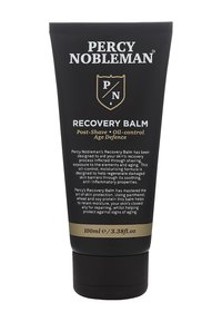 Zwarte tube met gouden accenten, voorzien van witte tekst. Inclusief een verzegelde dop en etiket met de tekst "Recovery Balm" en productdetails. Inhoud van 100 ml.