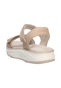 Sandalias de plataforma beige con correas ajustables, parte superior sintética, plantilla suave y suela texturizada. La suela blanca ondulada proporciona agarre.