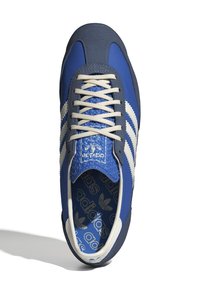 Blue athletic shoe with a textured upper, white stripes, cream laces, and a patterned interior. Features a contrasting grey heel and tongue.