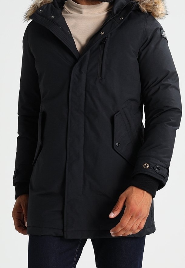 Svart parkas med en huva fodrad med päls, har en dragkedja och tryckknappslås, bröstficka och sidofickor; tillverkad av ett vattentåligt material.