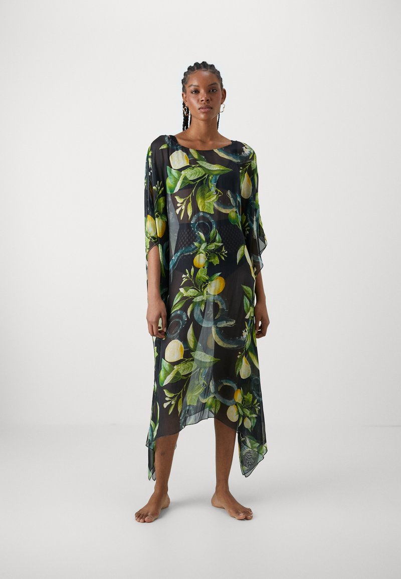 Kaftan nero trasparente con un vivace motivo di frutta e foglie in verde e giallo, con una forma ampia e un orlo asimmetrico.