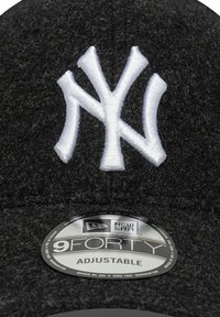 Svart filt cap med hvit NY-logo brodert på forsiden. Har justerbart belte og et sølv 9FORTY-merke på skjermen.