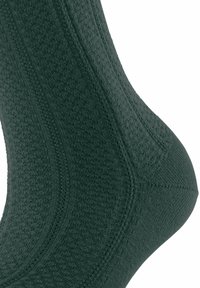 Chaussette en coton vert foncé avec un motif tricoté texturé, avec des zones de renfort au talon et aux orteils, et une finition lisse.