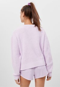 Jasnofioletowy sweter z dzianiny z prążkowanym dołem i mankietami, w połączeniu z pasującymi jasnolawendowymi szortami. Teksturowany materiał o luźnym kroju.