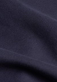 Mörk marinblå tyg med en jämn struktur, något ribbat mönster och mjuk yta, vikt för att avslöja djup och subtila fibrer.