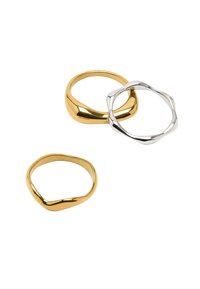 Zestaw trzech pierścionków: jeden gładki złoty pierścionek, jeden skręcony srebrny pierścionek oraz złoty pierścionek o falistym wzorze. Wszystkie mają polerowane wykończenie.