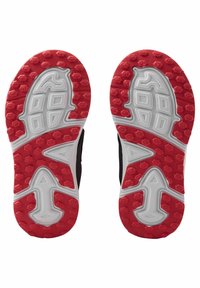 Czarne sportowe podeszwy butów z teksturowanym czerwonym wzorem z gumy z białymi akcentami. Design zawiera rowki dla lepszej przyczepności.