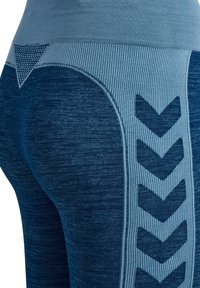Blaue Leggings mit hohem Bund, die ein strukturiertes Design mit Zickzackmustern und gerippten Akzenten für zusätzliche Details und Stil aufweisen.