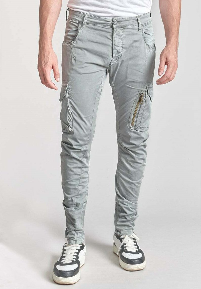 Pantalons cargo gris clair avec une coupe slim, comprenant des zips diagonaux et plusieurs poches, fabriqués à partir d'un tissu doux et texturé.