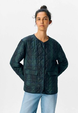 Quiltet jakke i mørkegrøn med ternet mønster, med rund halsudskæring, knapper foran og to sidelommer.