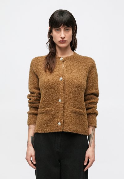 Cardigan marron texturé avec un col rond, des manches longues et des poches avant, orné de boutons argentés brillants sur le devant.
