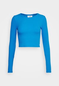 Langærmet crop top i lyseblåt ribbet stof. Har rund halsudskæring og tætsiddende design. Enkel og sømløs konstruktion.