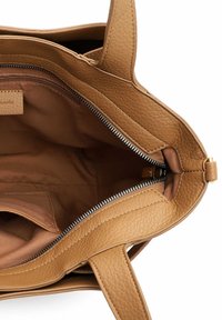 Brązowa skórzana torebka o fakturowanej powierzchni, z odsłoniętym suwakiem, przez który widać brązową, materiałową wyściółkę z wewnętrzną kieszenią na zamek i płaską kieszenią.