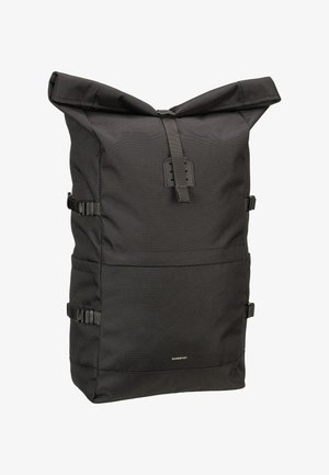 Sac à dos noir à rabat fabriqué en tissu texturé. Comprend des sangles latérales ajustables, une base plate et un branding minimaliste à l'avant.