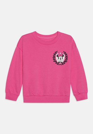 Lyserød langærmet sweatshirt med rund hals, med et lille Minnie Mouse-ansigt med sløjfe indeni en sort laurbærkrans på brystet.