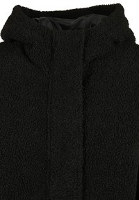 Veste polaire noire texturée avec un col haut et une doublure intérieure lisse, conçue pour la chaleur et le confort.