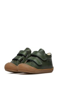 Scarpe in pelle verde con due cinturini in velcro regolabili, suola in gomma marrone con grip testurizzato e design a punta rotonda.