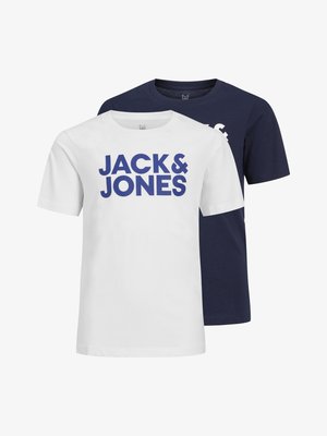 Hvit t-skjorte med korte ermer og blå "JACK & JONES" tekst, kombinert med mørkeblå denimjeans og marineblå joggesko med hvite såler.