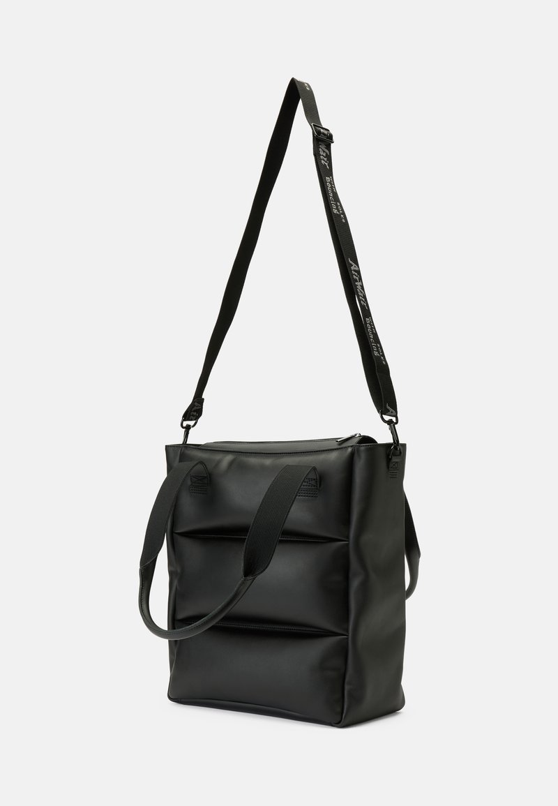 Zwarte tote bag gemaakt van soepel materiaal, met dubbele handvatten en een verstelbare schouderband, met een gestructureerd ontwerp en accenten op het voorpaneel.