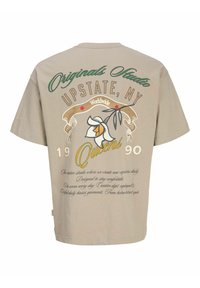 Beež t-särk tekstiga "Originals Studio Upstate, NY Queens 1990", lilleillustatsioon ning lisakaunistav kiri seljal.