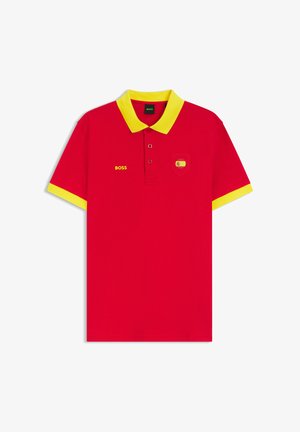 Rood poloshirt met gele kraag en mouwboorden, "BOSS" tekst op de linkerborst en een klein patchje met de Spaanse vlag op het rechter borstzakje.