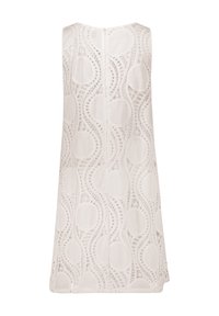 Weißes ärmelloses Kleid mit einer Spitzenoberfläche im Wellenmuster und kreisförmigen Ausschnitten, das bis zur Mitte des Oberschenkels reicht und einen Reißverschluss hinten hat.
