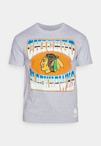 Camiseta de algodón gris con un texto llamativo "Chicago Blackhawks" y un gráfico de una cabeza de indígena con acentos de plumas coloridas.