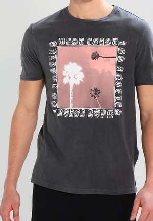 T-shirt de couleur noire délavée avec une image carrée de trois palmiers sur un ciel rose, bordée d'un texte stylisé indiquant "West Coast Los Angeles".