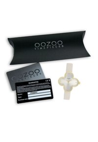 Montre Oozoo avec bracelet en silicone blanc, accents dorés et un cadran en forme de fleur en argent. Comprend une carte de garantie noire et un emballage.
