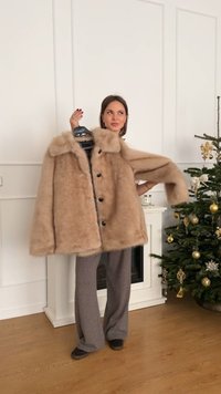 Palton din blană artificială, maro deschis, cu guler lat, închidere cu nasturi pe față și umeri căzuți. Material texturat care adaugă volum.