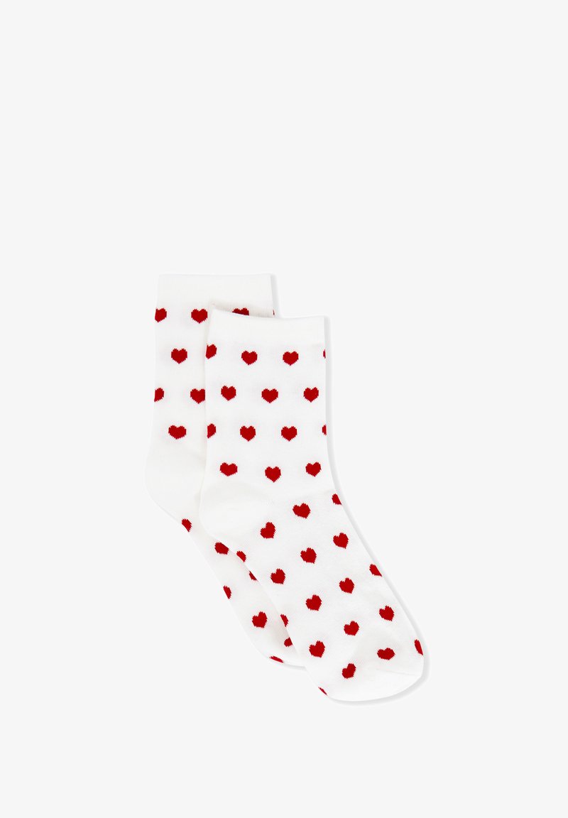 Calcetines blancos hasta el tobillo con un patrón de pequeños corazones rojos espaciados uniformemente.