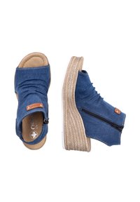 Dżinsowe sandały z odkrytymi palcami z beżową, wyściełaną wkładką, plecioną śródpodeszwą z jutą i zamkami błyskawicznymi po bokach umożliwiającymi regulację dopasowania.