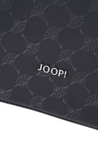Svart tygpåse med ett subtilt mönster, med en silverfärgad "JOOP!"-logotyp. Texturerad yta med dragkedjestängning och förstärkt sömnad.