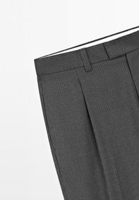 Pantalon de costume gris foncé à fines rayures, avec passants de ceinture, plis à l'avant et poches latérales sur fond blanc.