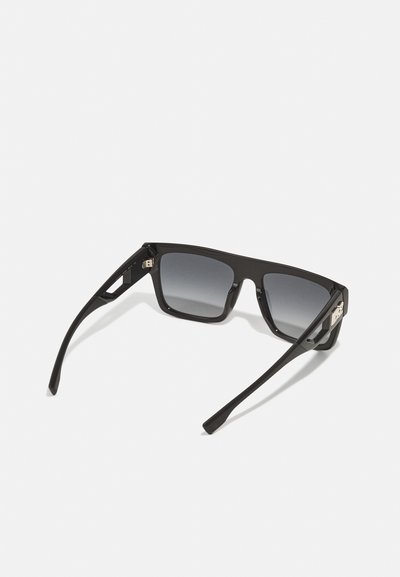 Occhiali da sole neri rettangolari con lenti grigie sfumate, montatura in plastica lucida e dettagli metallici sui lati. Bracciatura bicolore con superficie liscia.