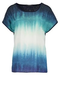 Top de manga corta en degradado de verde azulado a azul, con una textura suave y un patrón de puntos cerca del dobladillo. Cuello redondo y corte relajado.